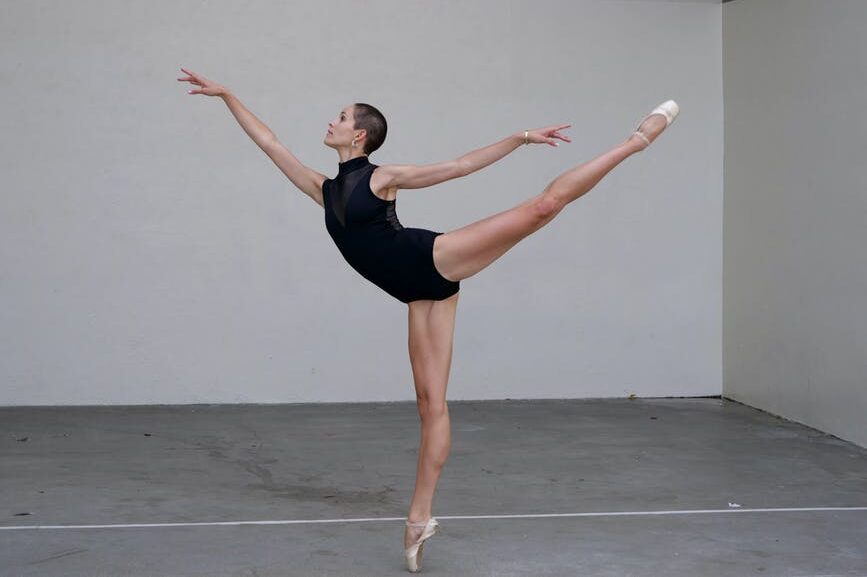 Ballerina expressing disciplined embodiment, balance, and effortless movement representing cultivation without striving.