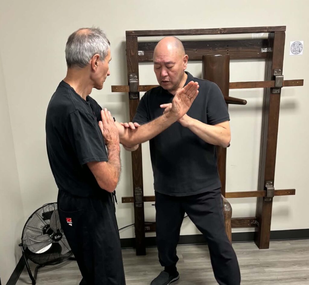 Close-up martial arts structure testing demonstrating how light pressure exposes alignment and force transmission weaknesses.
