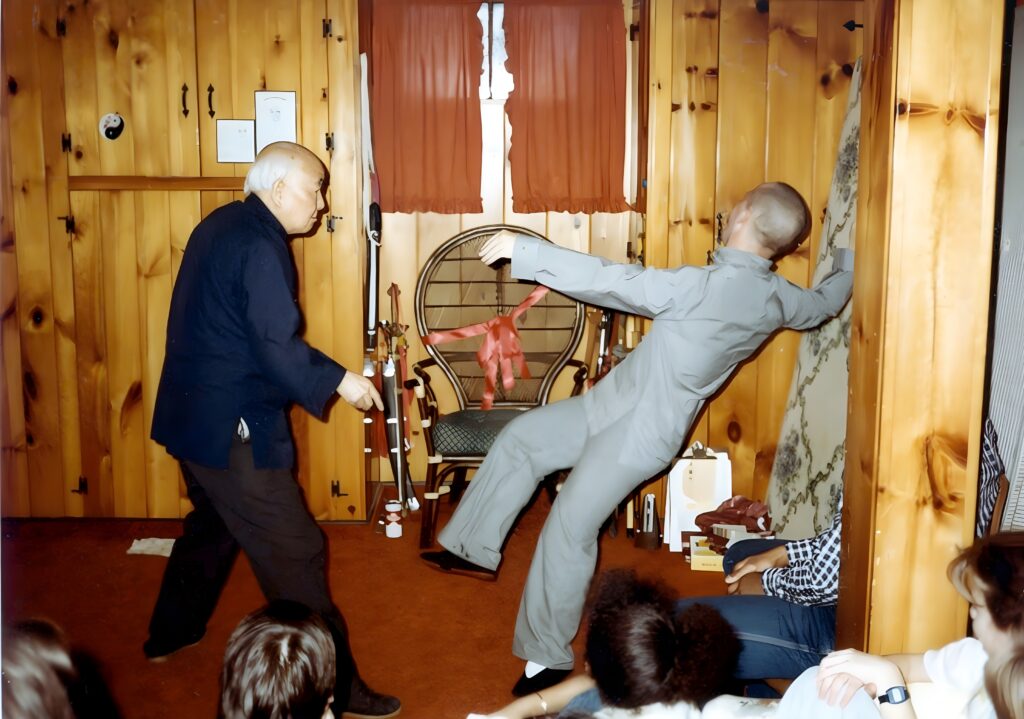 Young Stuart Olson being uprooted by Tai Chi master T.T. Liang during push hands training