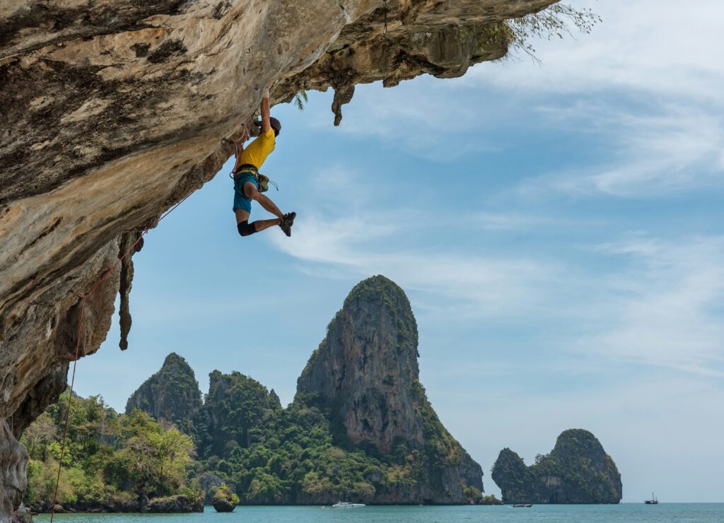 A rock climber navigating an overhanging cliff, illustrating embodied skill, flow state, adaptive perception, and continuous reorganization during complex movement.