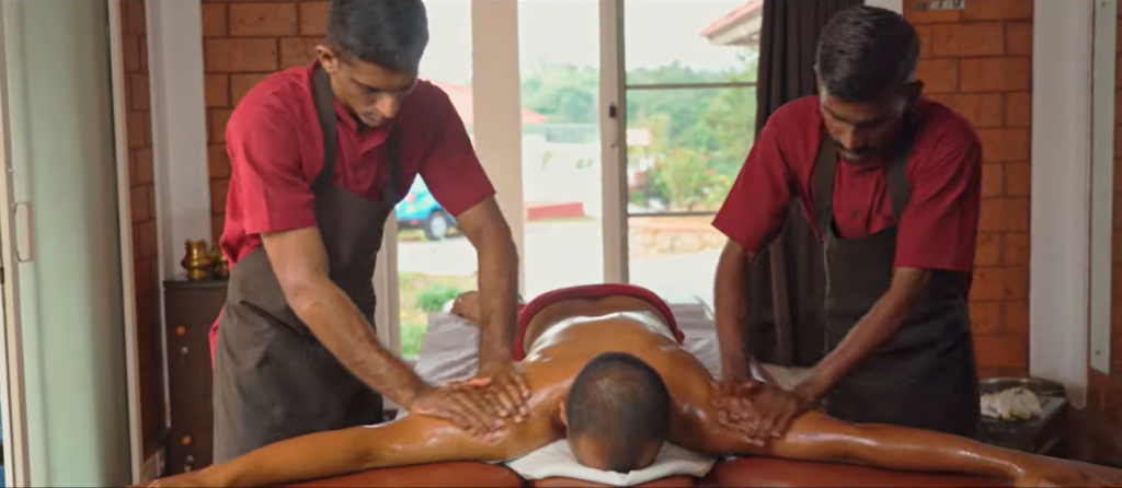 Practitioners applying traditional Ayurvedic oil massage at Indimasi Healing Village