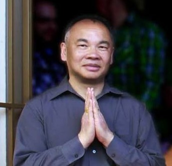 Deng Ming-Dao, Taoist author and teacher, with hands together in a traditional greeting.
